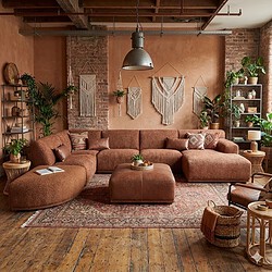 Kleurrige moderne woonkamer met grote bank, natuurlijke decoratie en vintage details, perfect voor een gezellige en stijlvolle sfeer.