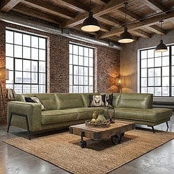 Stoere groene leren hoekbank in industrieel interieur met brickmuren en houten plafond, perfect voor moderne woonkamers met stijlvolle Mokana meubels.