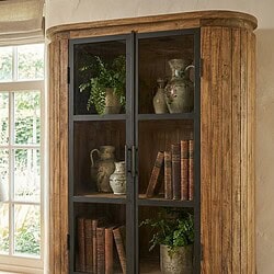 1. Luxe houten vitrinekast met zwarte metalen rand, ideaal voor het tonen van antieke vazen en boeken in een woonkamer of keuken.