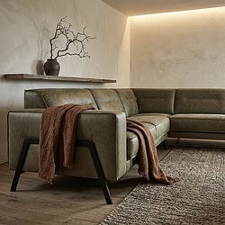 Moderne groene hoekbank Vegas met zwarte poten in een minimalistische woonkamer.