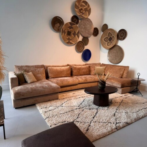 Unieke houten wanddecoraties op de muur boven een stijlvolle vintage bank, perfect voor een warme en gezellige woonkamer inrichting.