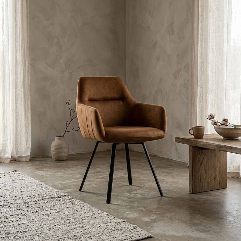 Moderne cognackleurige eetkamerstoel Raaf met comfortabele bekleding en slanke zwarte metalen poten, perfect voor een stijlvolle eetkamer.