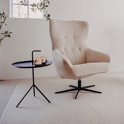 Luxe beige relaxfauteuil met moderne zwarte onderstel en bijpassende bijzettafel, perfect voor een gezellige zithoek met stijlvolle meubels.