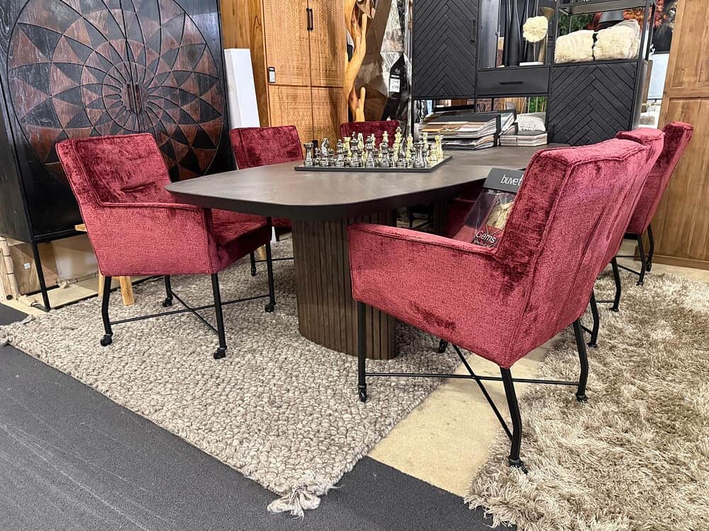 Modern eettafel met velvet rode stoelen en zwart metalen poten, stijlvolle en gezellige eetkamer meubels van Mokana Meubelen.