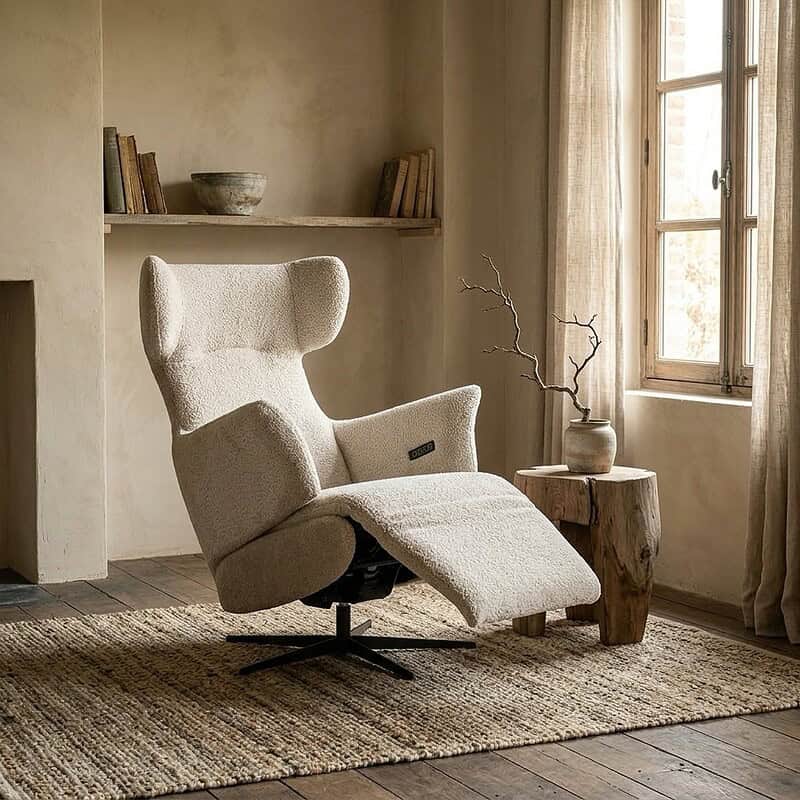 Luxe relaxfauteuil Jada HE in een rustieke woonkamer met natuurlijke lichtinval en minimalistisch interieur. Perfect voor comfort en stijl.