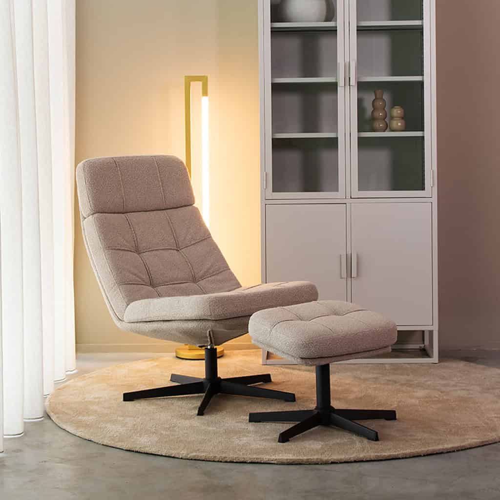 Design fauteuil met bijpassende voetenbank in een modern interieur, perfect voor ontspanning en stijlvolle woondecoratie.