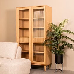 Houten kast met glazen deuren en open vakken in woonruimte.