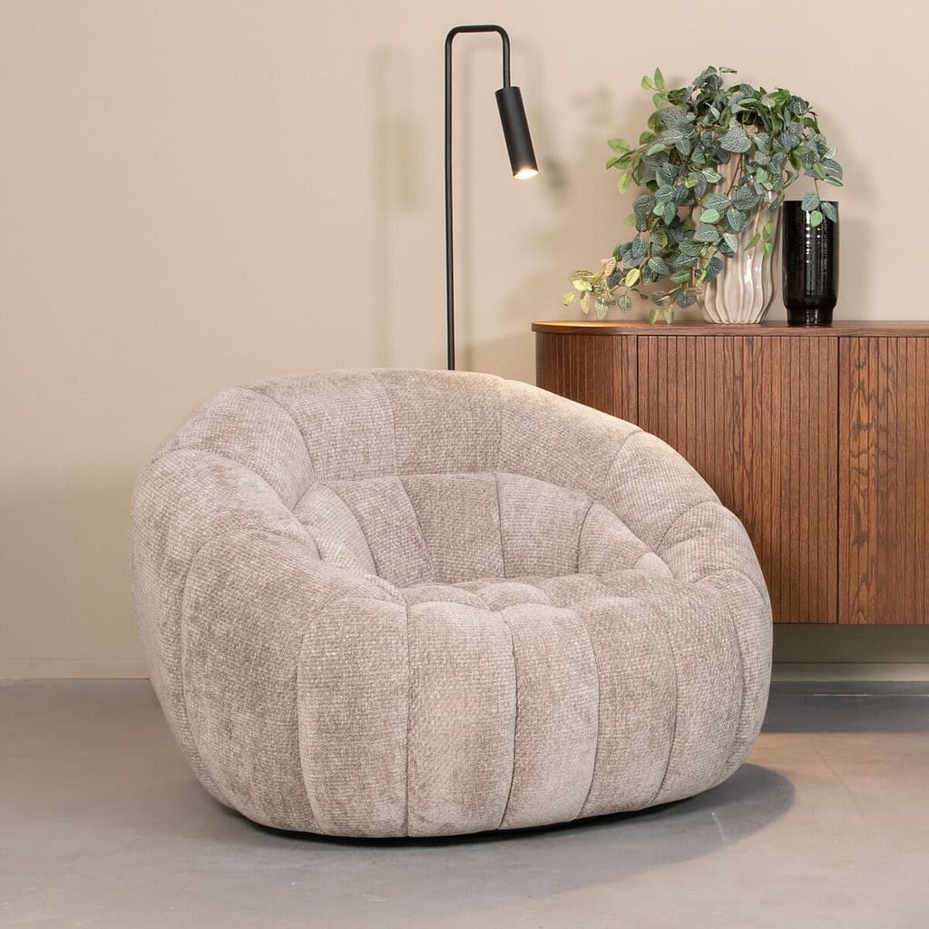 Soft beige stoffen fauteuil, perfect voor een moderne woonkamer of lounge. Elegant en comfortabel met een rond, gestikte structuur voor een stijlvolle uitstraling.