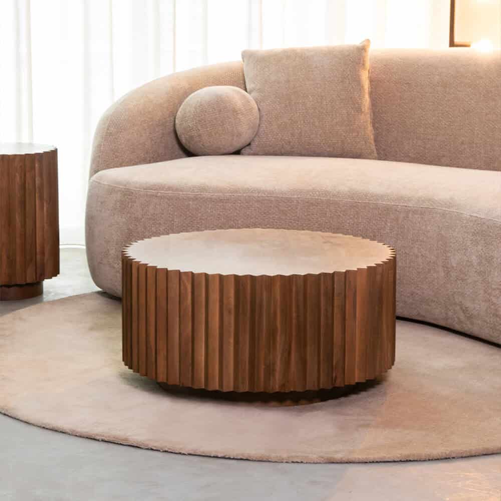 Eikenhouten salontafel met unieke, gedetailleerde randafwerking in een modern woonkamer met zachte bank en natuurlijke verlichting.