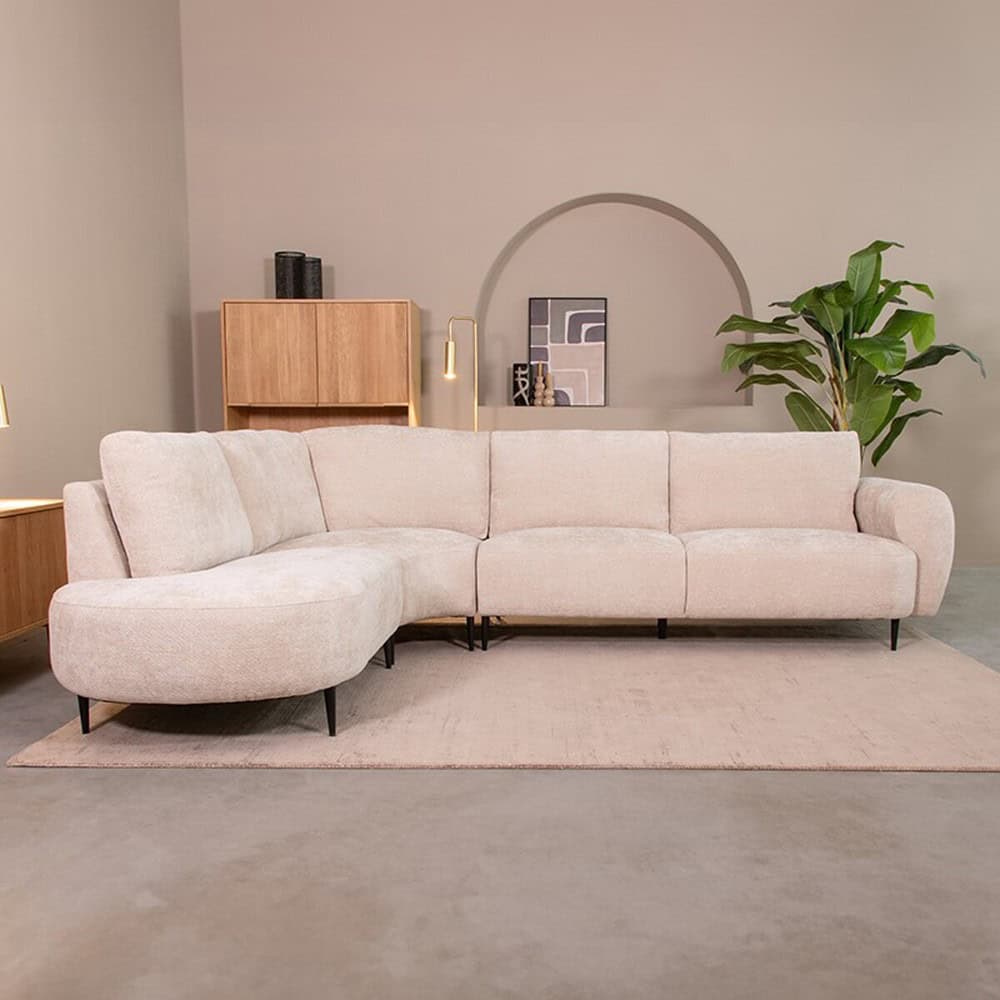 Luxe L-vormige woonkamerbank van Mokana Meubelen in een modern interieur met beige tinten, houten meubels en groene planten. Perfect voor een stijlvolle en comfortabele zithoek.
