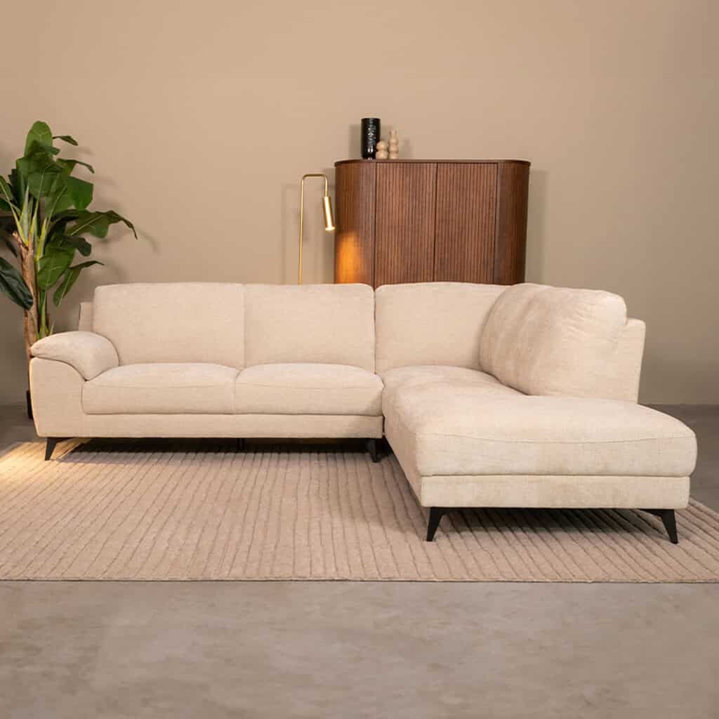 Elegante hoekbank met licht beige bekleding, perfect voor stijlvolle woonkamer inrichting en comfortabel loungen. Uitstraling van modern Scandinavisch design.