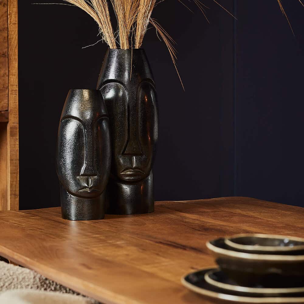 Moai stijl zwarte decoratieve vazen op houten tafel, modern Afrikaans geïnspireerd design, stijlvolle interieur accessoires, unieke kunstobjecten, keramik details, elegant en exotisch sfeerfoto.