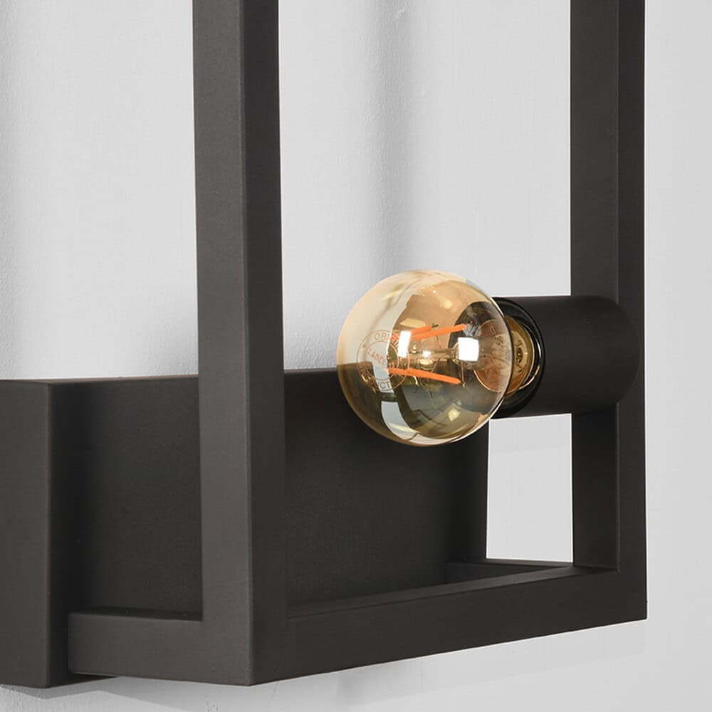Eenvoudige zwarte wandlamp met zichtbaar filament gloeilamp, modern en industrieel design voor woonkamer of kantoor.