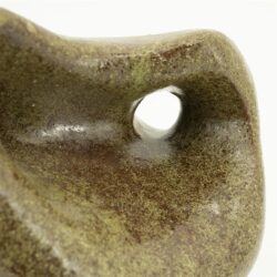 Ruwe close-up van een houten meubel met een holle opening, voorzien van een groene-mossige afwerking en natuurlijke textuur. Perfect voor natuurlijke en ambachtelijke meubels, gemaakt door Mokana Meubelen.