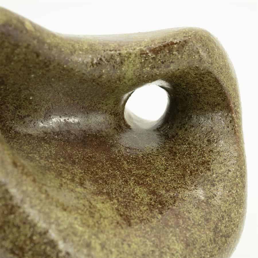 Ruwe close-up van een houten meubel met een holle opening, voorzien van een groene-mossige afwerking en natuurlijke textuur. Perfect voor natuurlijke en ambachtelijke meubels, gemaakt door Mokana Meubelen.