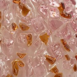 Glas met roze en amberkleurige ijsblokjes, close-up, voor gezelligheid en warmte.