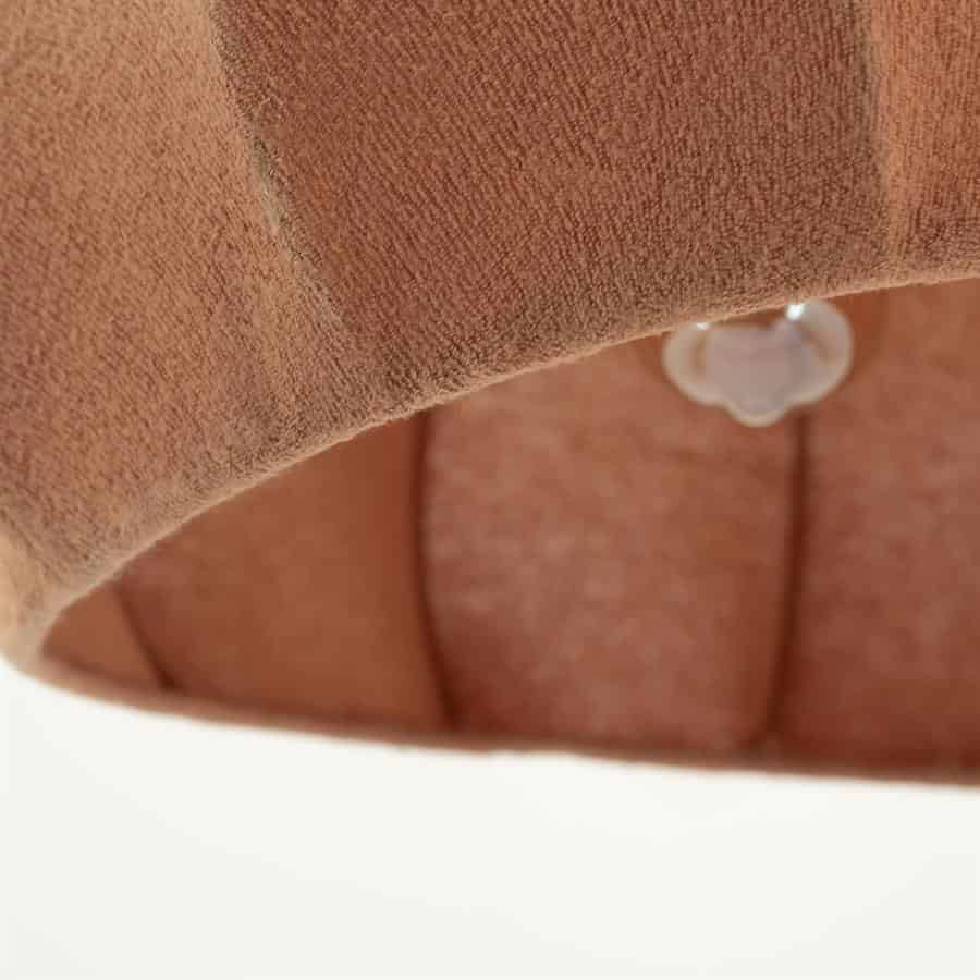 Zachte, gematigde stoffen bekleding van een Mokana fauteuil in aardetinten, met knoopdetails voor een comfortabele en stijlvolle uitstraling.