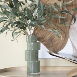 Vl uutselijke groene vazen met eucalyptus takken op een houten kast, moderne interieurdecoratie, Mokana Meubelen, stijlvolle woonaccessoires, natuurlijke uitstraling, elegant design.