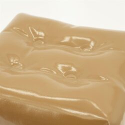 Romige karamelkleurige bankdruk met knoopdetails, modern en comfortabel, perfect voor een stijlvolle woonkamer.