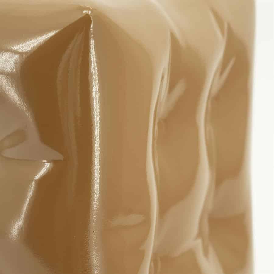 Vernieuwde close-up van een glanzende, beige bekleding van Mokana Meubelen, highlighting de look en textuur van hoogwaardig meubelstoffering.