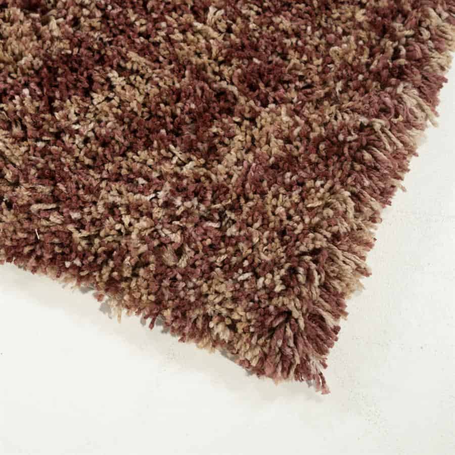 Ruw vloerkleed met een chunky, textuurrijke structuur in aardetinten van bruin en beige, perfect voor moderne en gezellige binnenruimtes.