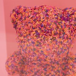 Gekleurde snoepjes bedekt met kleurrijke sprinkles, decoratief en speels, perfect voor feestelijke gelegenheden.