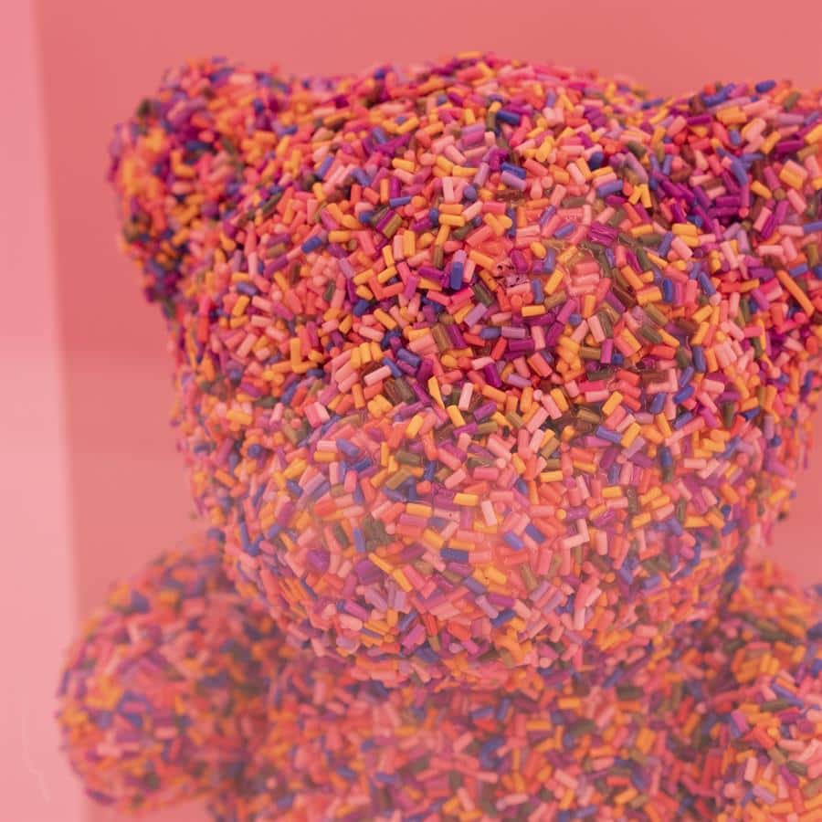 Gekleurde snoepjes bedekt met kleurrijke sprinkles, decoratief en speels, perfect voor feestelijke gelegenheden.