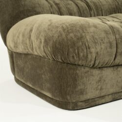 Zacht aangezette velvet stoffen bank met comfortabel zitvlak en rijkelijk gestikte details, perfect voor een luxe woonkamer.