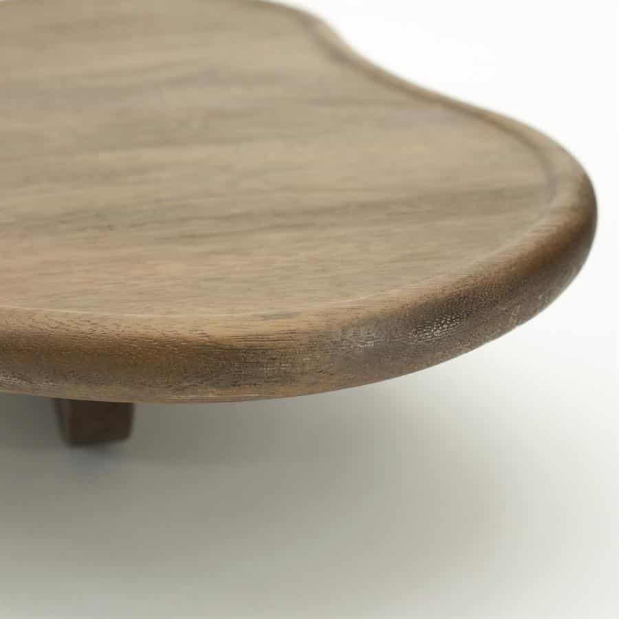 Elegante houten meubels, close-up van een ronde houten tafelrand met vakmanschap en natuurlijke houtstructuur. Perfect voor een moderne of rustieke interieurstijl bij Mokana Meubelen.