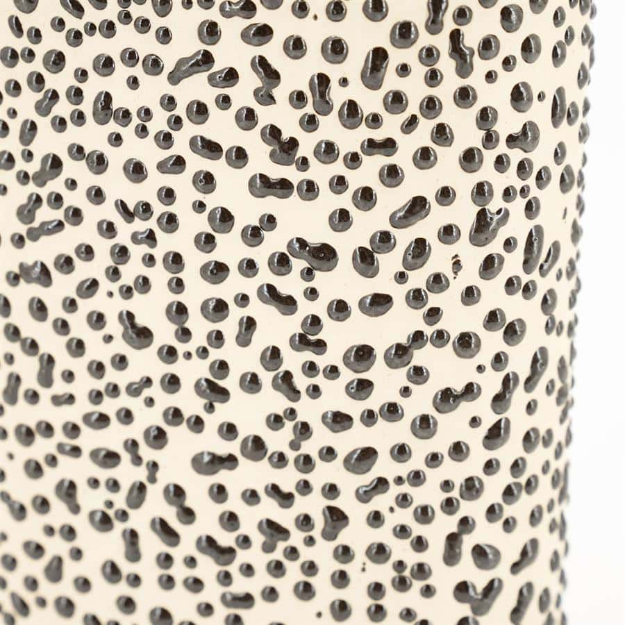 Luxe metalen vaas met zwarte stippen, modern design.