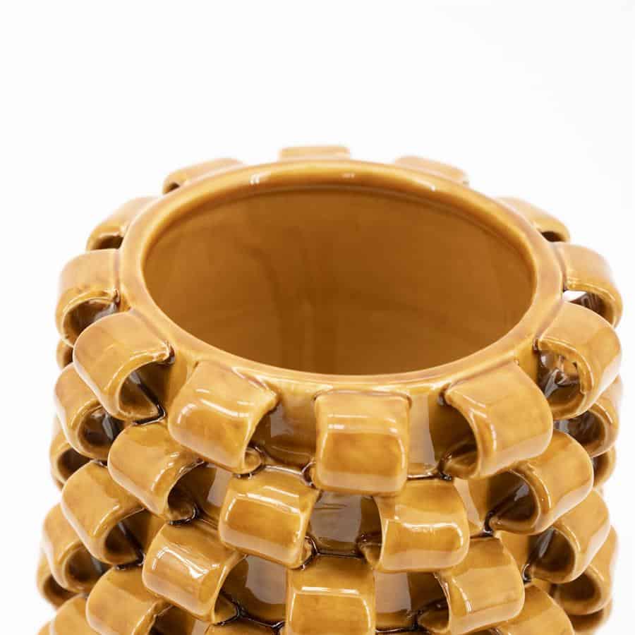 Vaas van keramiek met unieke gekartelde structuur in warme aardetinten, perfect voor interieuraccenten en bloemarrangementen.