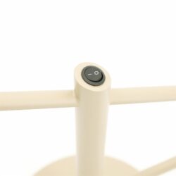 Zwarte aan/uit schakelknop op een modern wit meubelstuk, geschikt voor stijlvol wonen en slimme bediening.