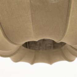 Vergroot onderkant van een beige stoffen fauteuil met gebogen armleuningen en kussens, officieel ontworpen door Mokana Meubelen, perfect voor comfortabel en stijlvol wonen.