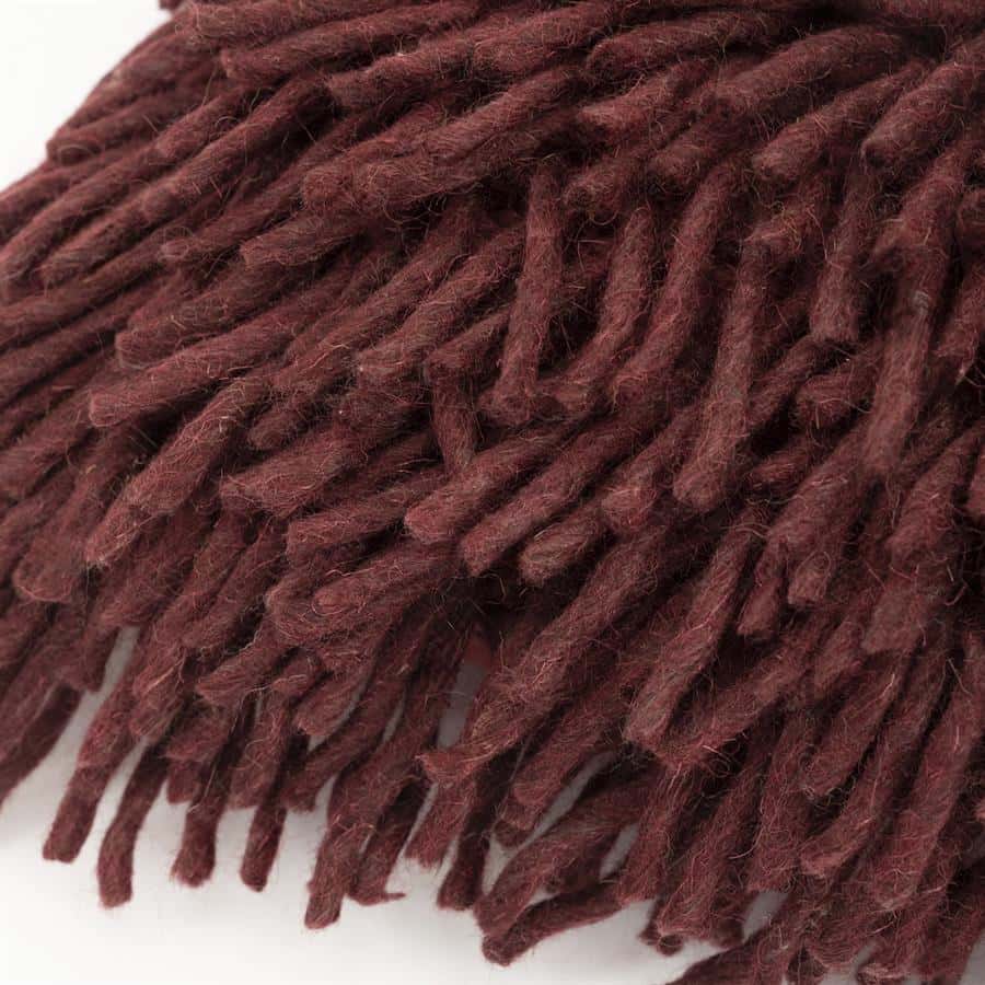 Warme roodbruine gehaakte wollen deken, perfect voor cosy wintersferen en duurzame inrichting.