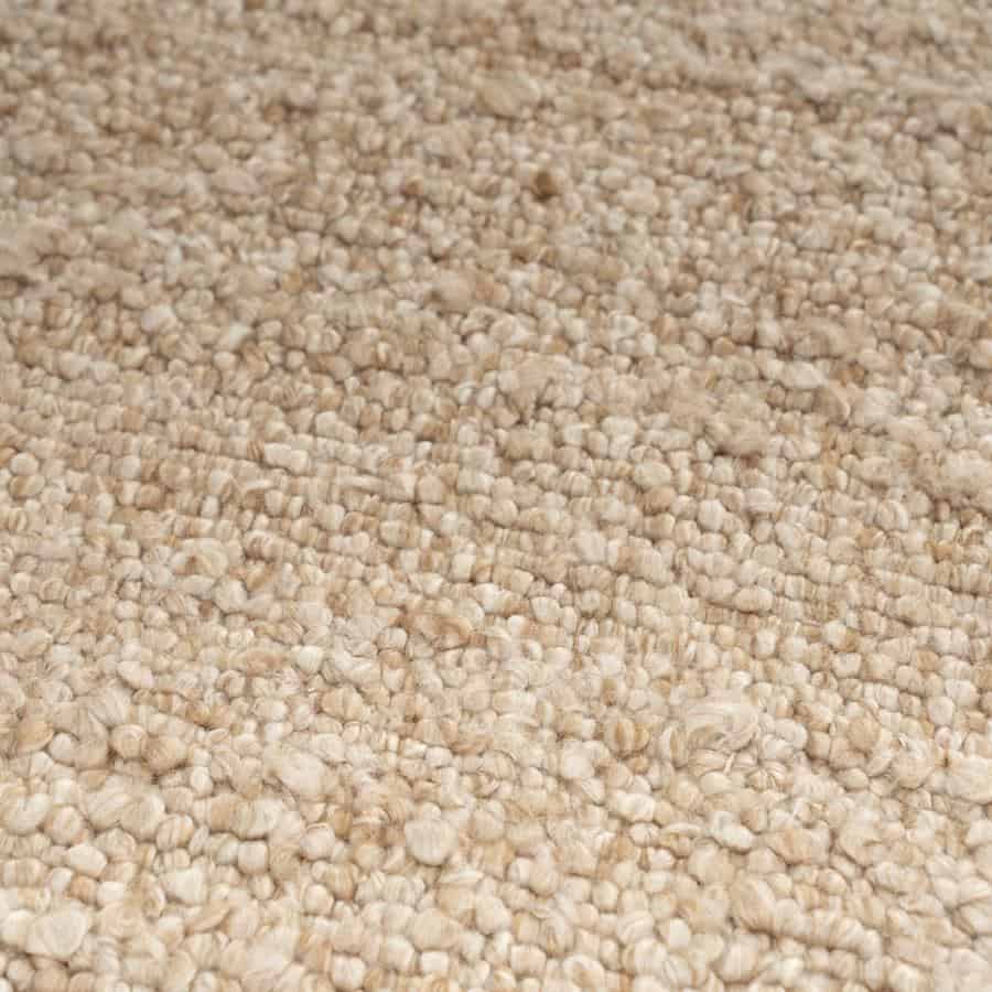 Zandkleurige, zachte tapijtvloer met textuur en brosse structuur, perfect voor een warme en gezellige woonkamer of slaapkamer.