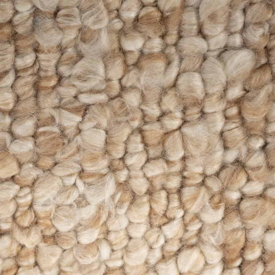 Zacht wollengevoerde stof met een krachtige textuur en natuurlijke tinten, perfect voor hoogwaardige meubelafwerking.