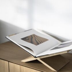 Elegante houten boekstandaard op een modern houten meubel, perfect voor het weergeven van boeken en tijdschriften. Stijlvol en functioneel voor een eigentijdse interieurstijl.