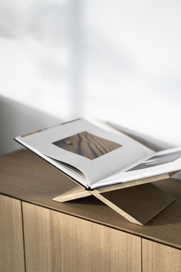 Elegante houten boekstandaard op een modern houten meubel, perfect voor het weergeven van boeken en tijdschriften. Stijlvol en functioneel voor een eigentijdse interieurstijl.