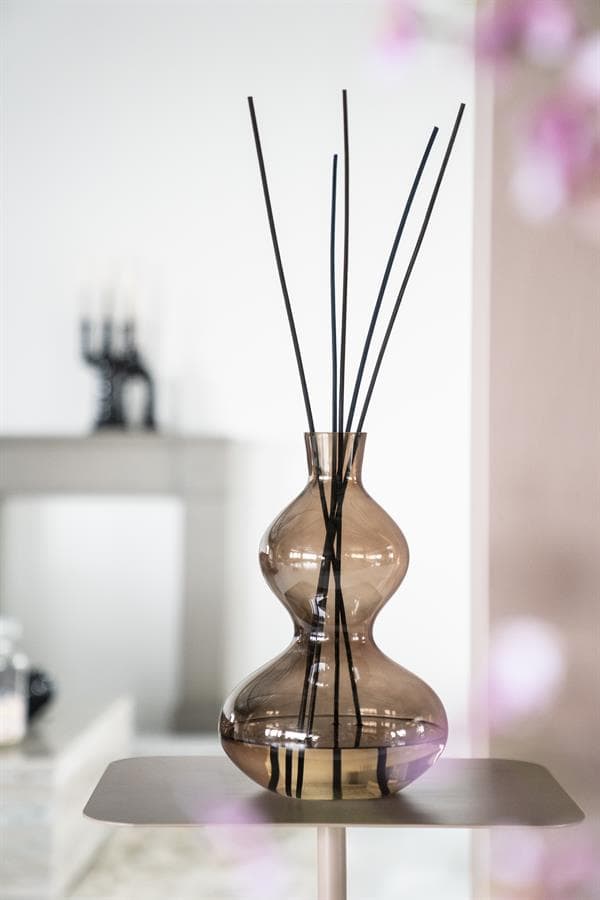 Elegant rumoerige glazen vaas met separatie-sticks voor stijlvolle interieurdecoratie.