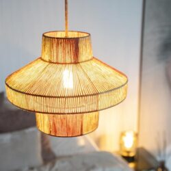 Uniek houten hanglamp boven een bed in een modern slaapkamer. Handgemaakte designverlichting van Mokana Meubelen voor een sfeervol en warm interieur.