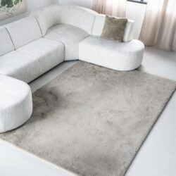Mokana meubelen witte loungebank met zacht kussen in een moderne woonkamer met beige gordijnen en een beige vloerkleed.