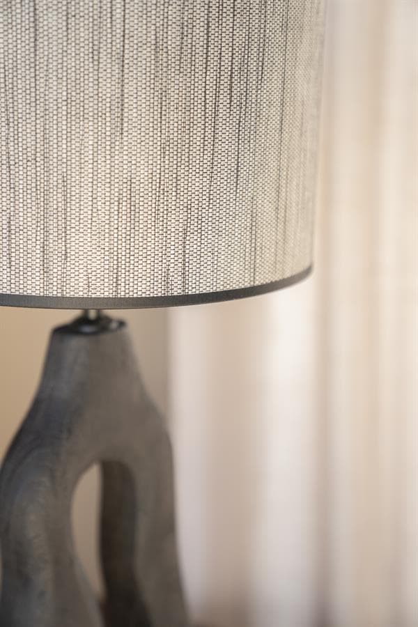 Vloerlamp met houten basis en stoffen kap, modern en stijlvol interieuraccessoire.