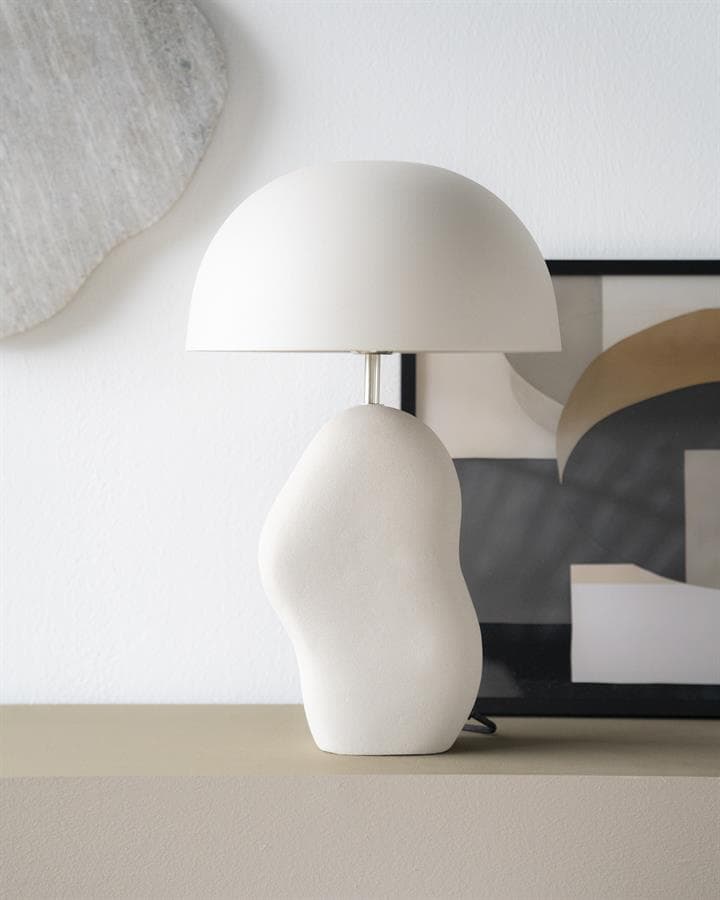 Vrouwelijke keramische tafel lamp in wit modern minimalistisch design op een dressoir, decoratie en verlichting voor een strak en elegant interieur.