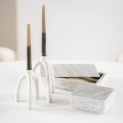Elegante witte kandelaars met houten kaarsen op een wit tafelblad, moderne en minimalistische interieur decoratie details.