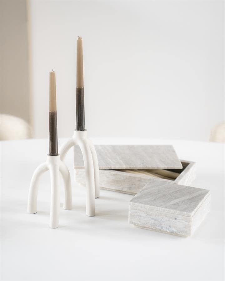 Elegante witte kandelaars met houten kaarsen op een wit tafelblad, moderne en minimalistische interieur decoratie details.
