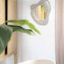 Moderne houten wandkast met plant en decoratief spiegel, minimalistisch interieur, natuurlijke materialen, designmeubelen, Scandinavisch stijl, woondecoratie, Mokana Meubelen.