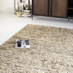 Kleine poster met kaarsen en smartphone op een beige en bruin gekleurd vloerkleed in een modern woonkamer.