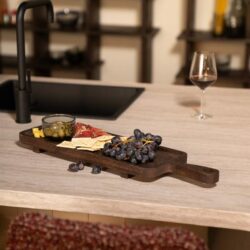 Gedekte natuurlijke houten keukenwerkblad met tapasplateau, wijnglas en aromatische snacks voor een gezellige eetkamer setting – perfect voor stijlvolle en functionele Mokana meubelen.