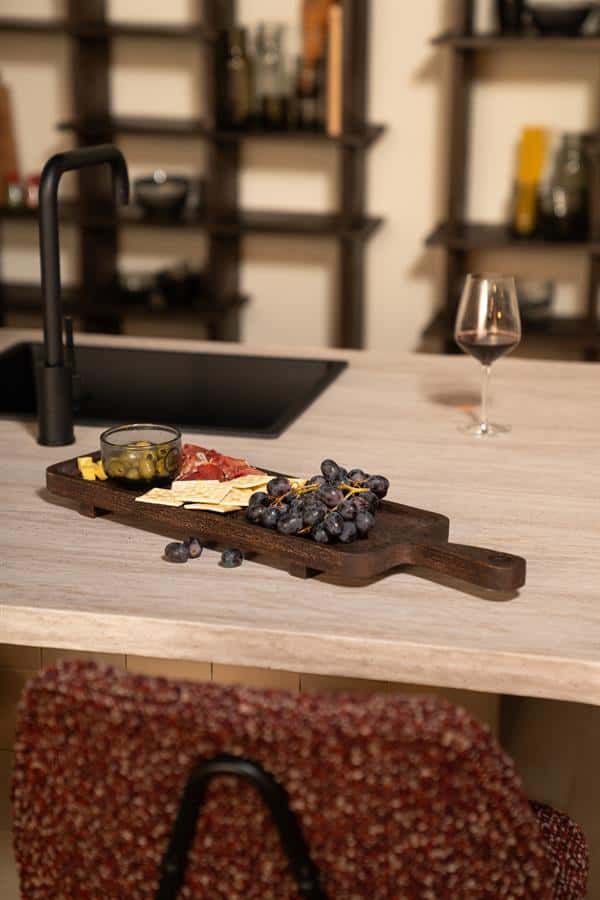 Gedekte natuurlijke houten keukenwerkblad met tapasplateau, wijnglas en aromatische snacks voor een gezellige eetkamer setting – perfect voor stijlvolle en functionele Mokana meubelen.