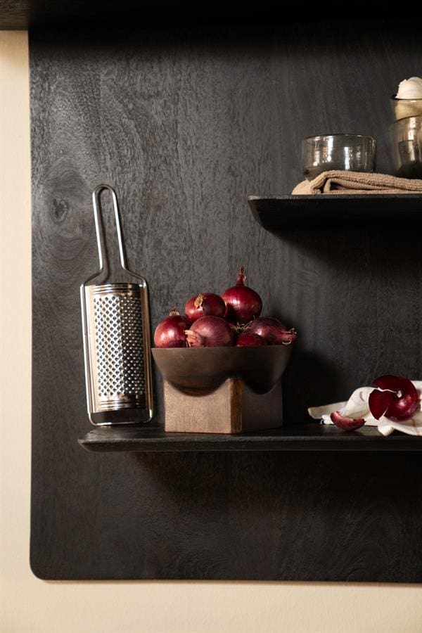 Aangepaste afbeelding met rode uien en keukengerei op een zwart houten plank, perfect voor moderne keukeninterieurs en food styling.